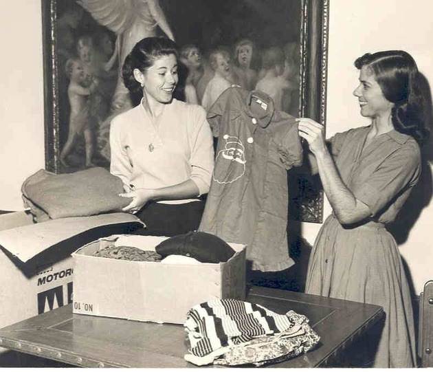 Students Carmen Dominguez and Frances Hickey putting children's clothes in boxes